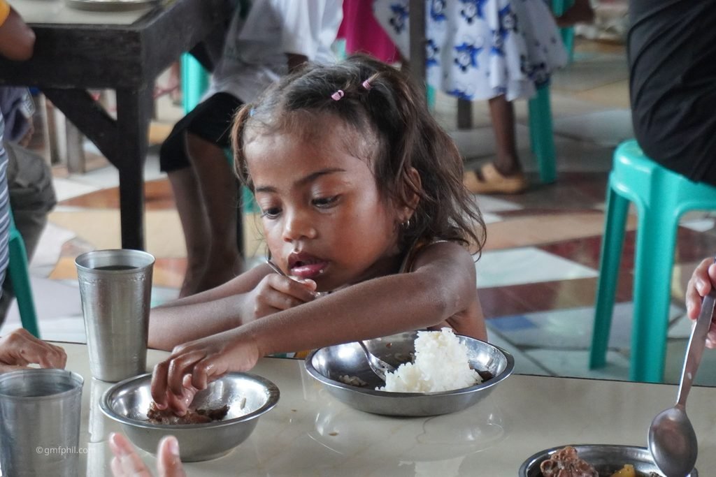 Aeta girl enjoys her meal.